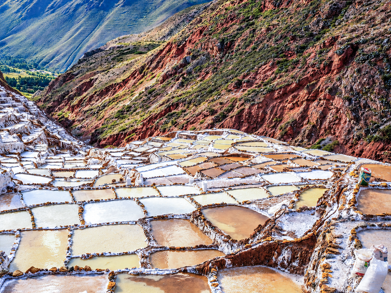 Hundreds of white salt ponds stepping down the hillside at the Maras salt mines